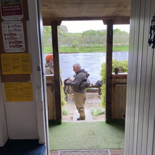 This is the scenery from inside the Newtyle Beat fishing hut in Birnam with the River Tay flowing past only a few yards away. The cobbled area where the fishing guest is standing and the big table behind him is a great area for outdoor lunches during periods of warm dry weather.